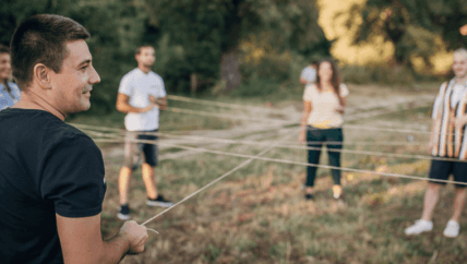 a group of people playing team building games outdoor